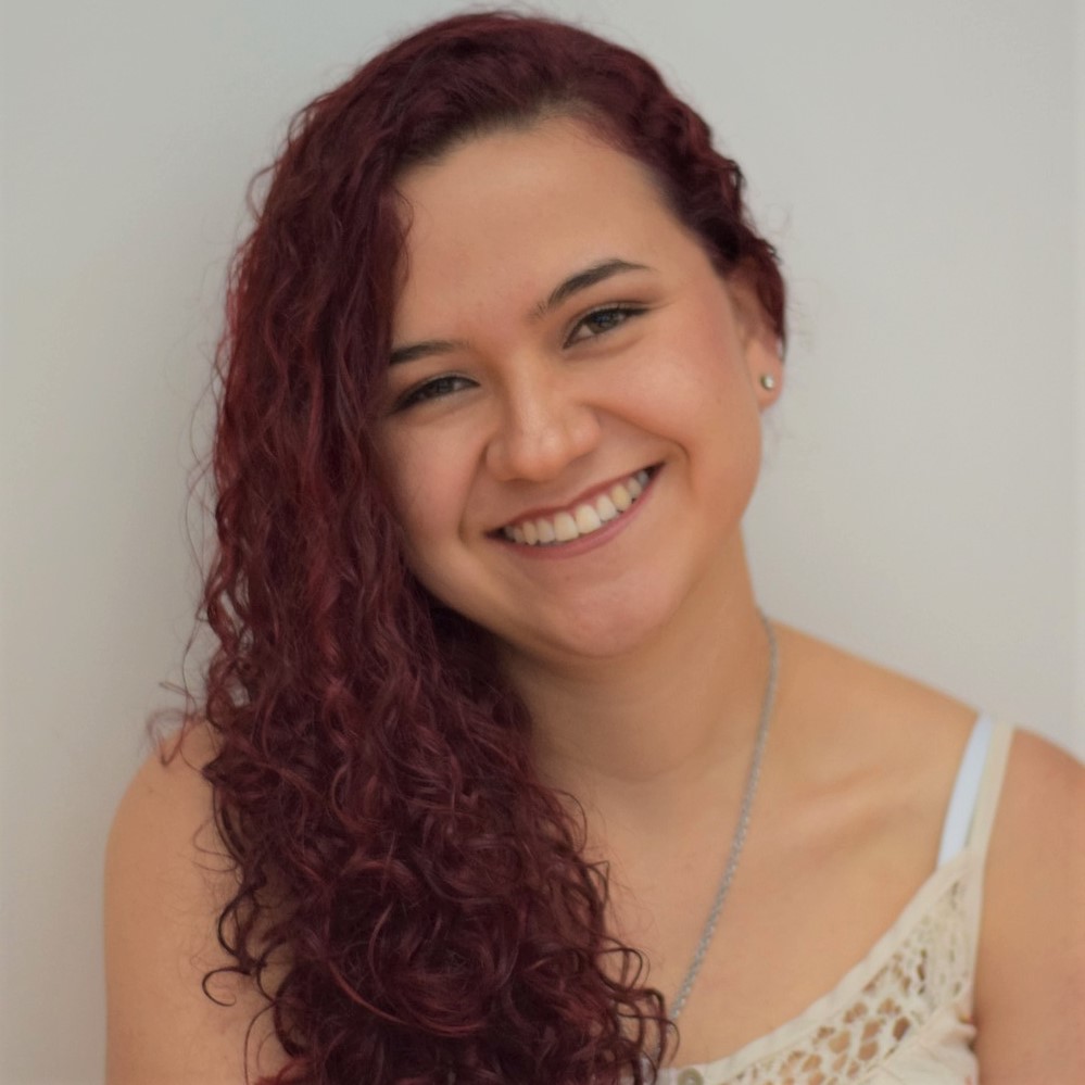 la imagen puede contener a una mujer de cabello rizado largo,posando muy alegre.